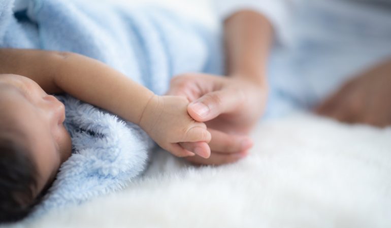 The baby is sleeping on a soft mattress